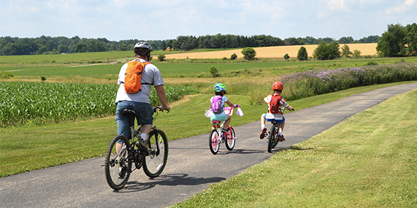 Father and kids biking at MetroParks Farm trailhead