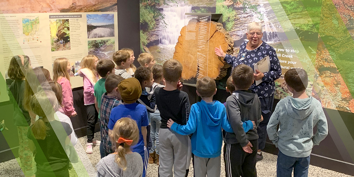 Book a Field Trip Page Header showing educator with a group of children at Ford Nature Center